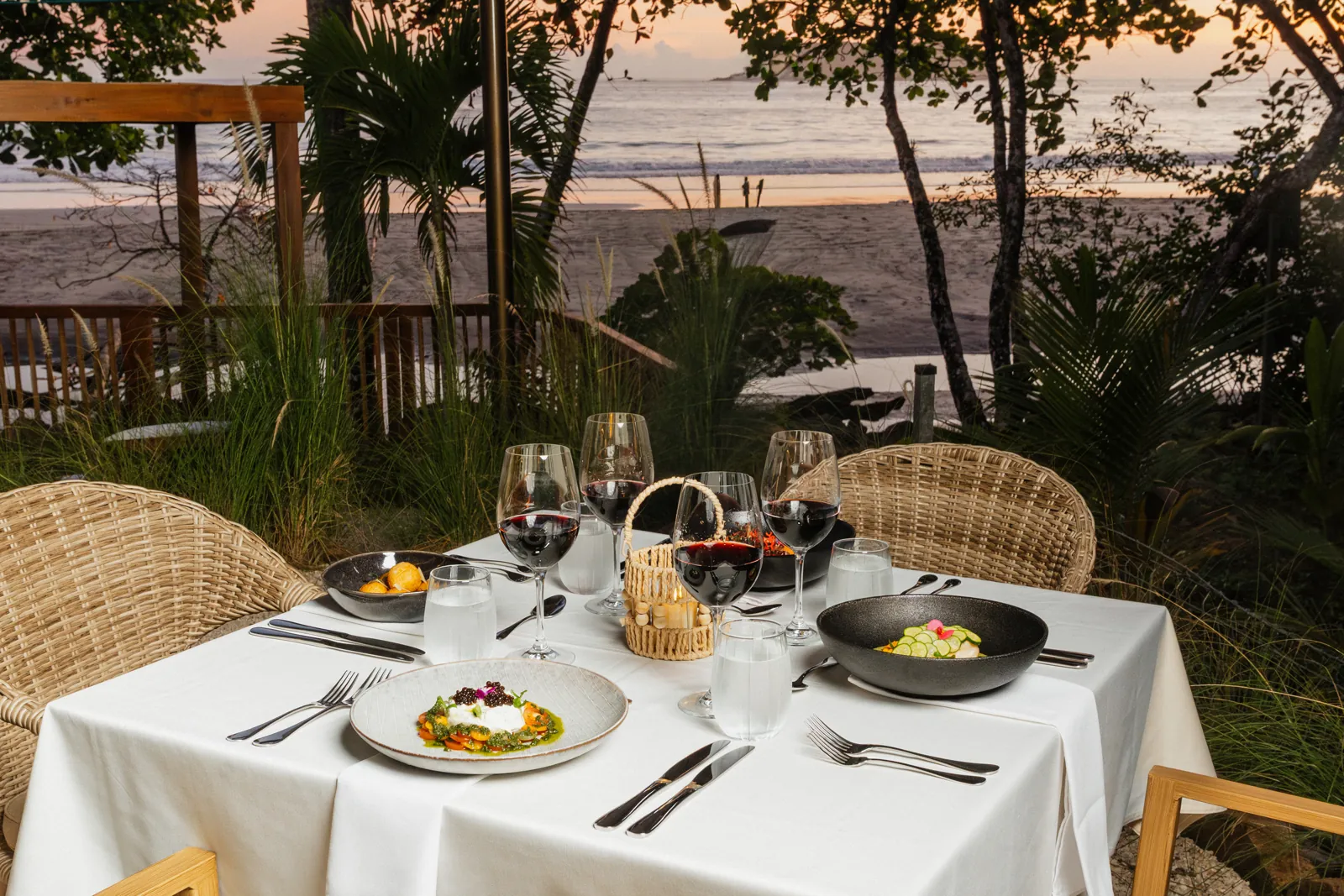 A table for two at Yemaya at sunset, the beach through the trees